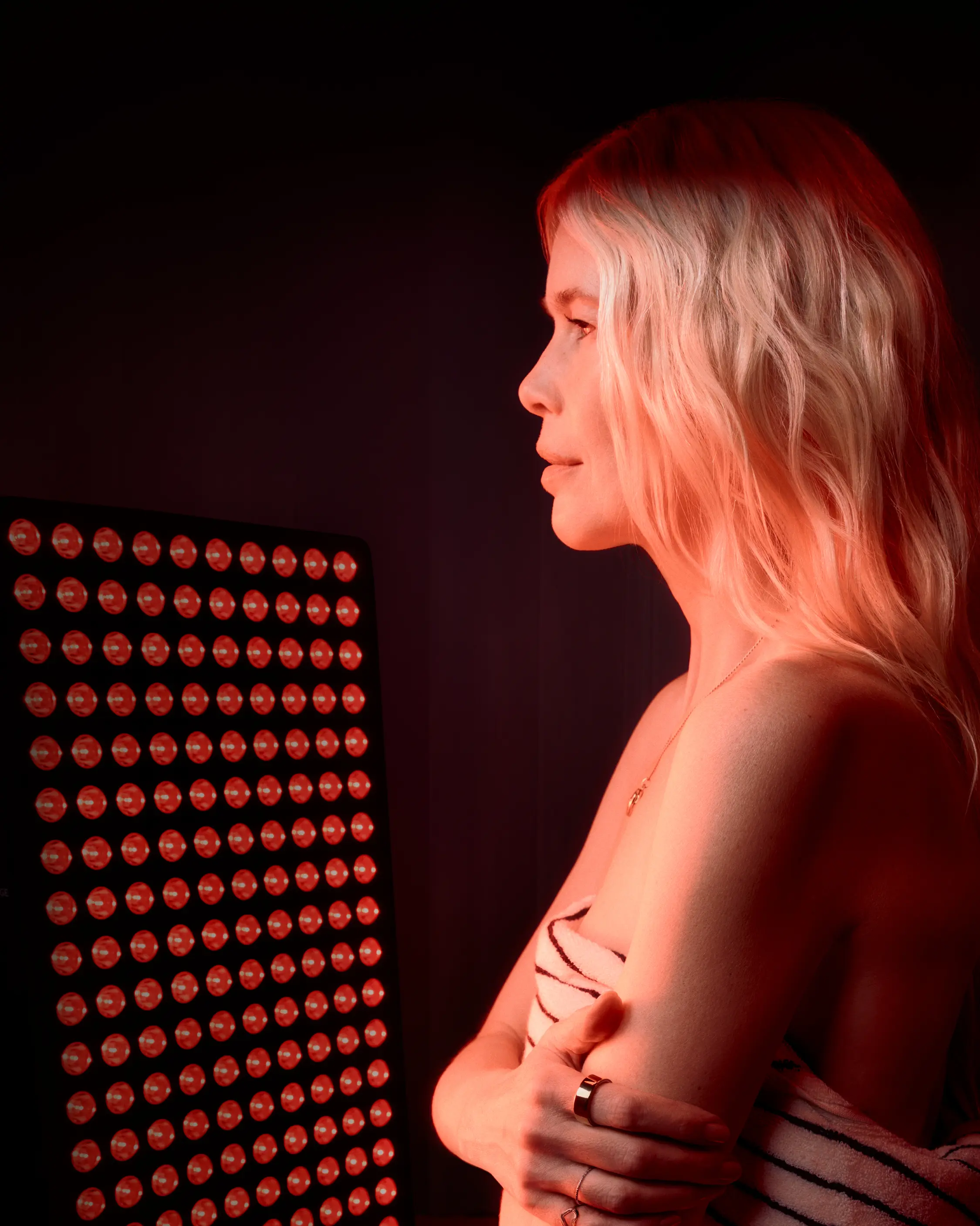 Woman practicing yoga with red light panel